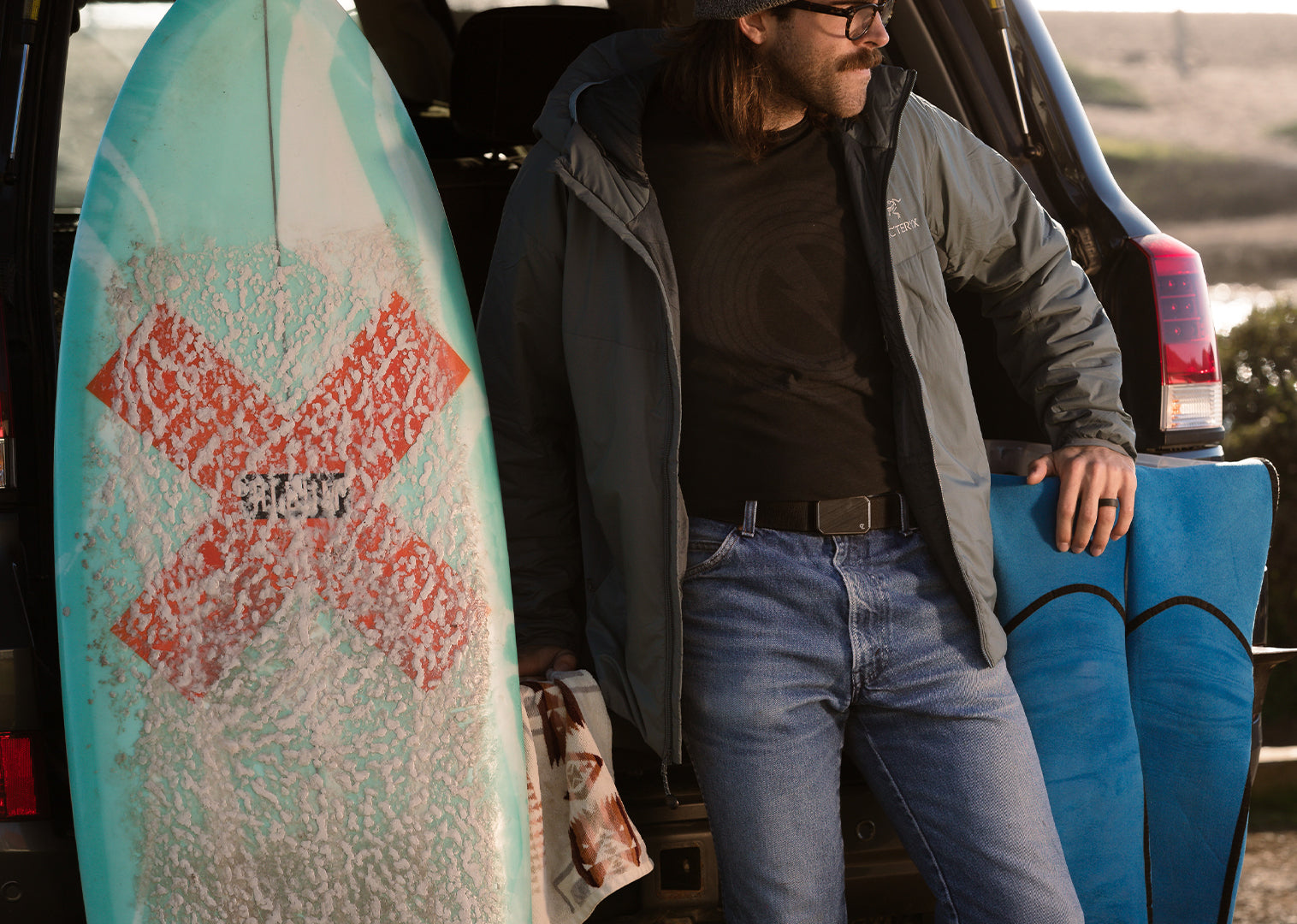 man holding a surf board wearing a Groove Life ring